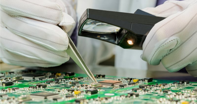 Worker conducting quality control on electronic components
