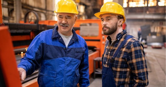 experienced manufacturing consultant talking to factory worker