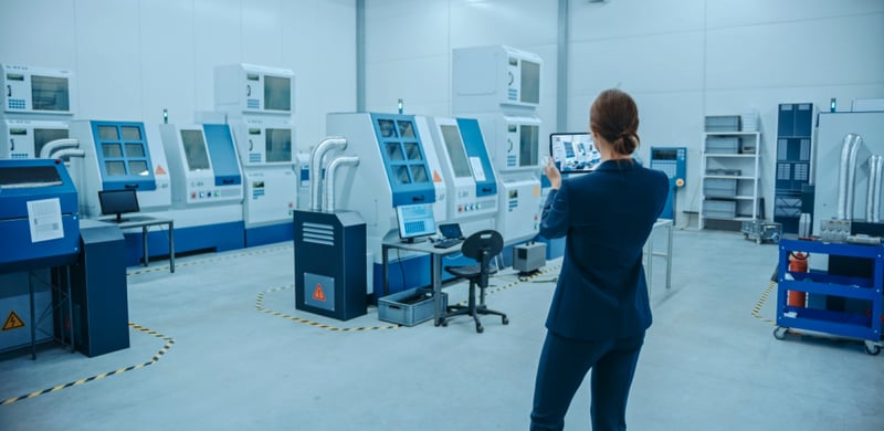 woman inspecting equipment layout in factory